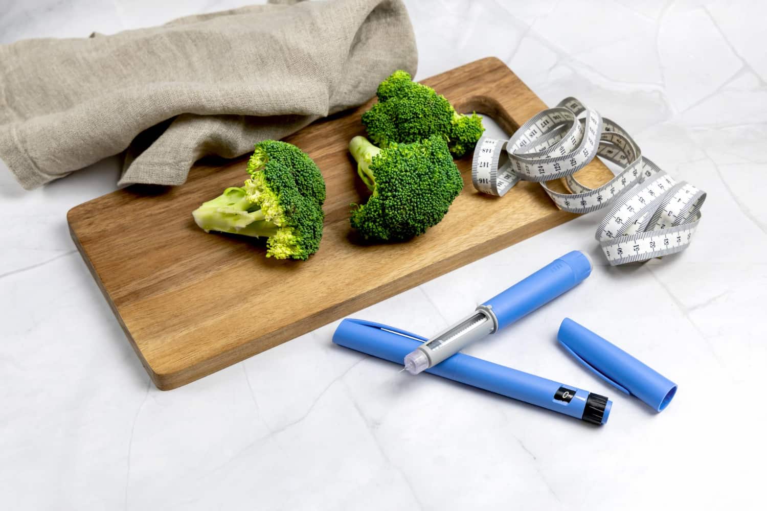 Photo of ozempic and broccoli on a cutting board